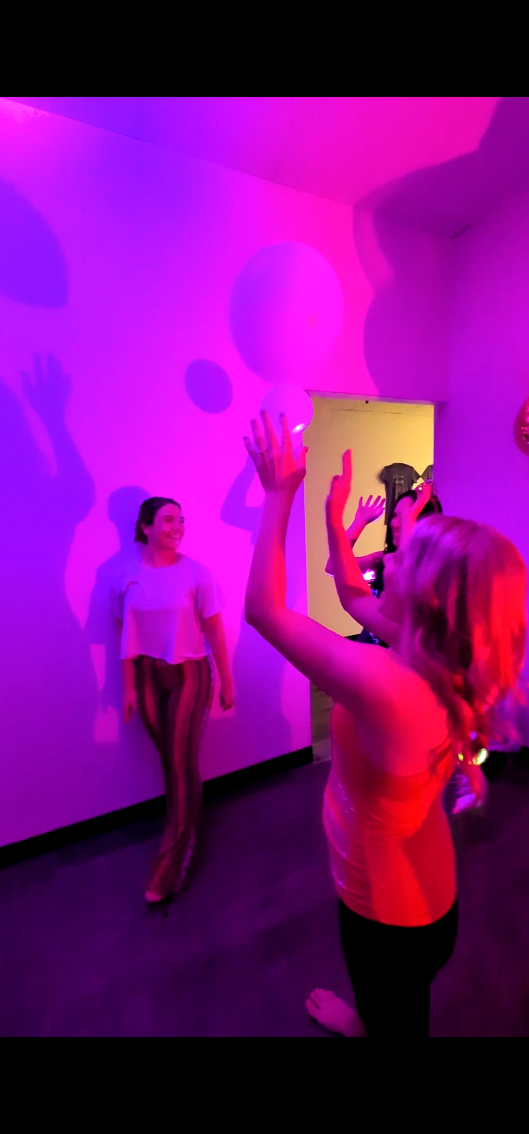 Guests dancing under pink and purple party lighting